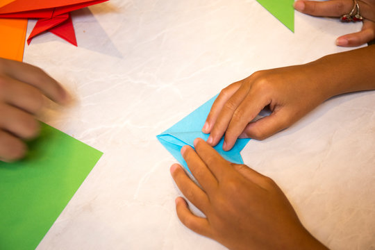 Child folding blue color paper