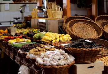 Snapshot of the Funchal market stall. Vegetables and fruits in baskets on the table. Background,...