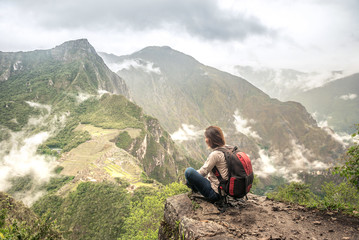 Girl-hiker looking on top of Huayna Picchu, looking on Machu Picchu