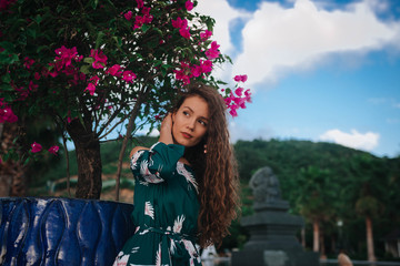  girl in a dress and a hat on a background of pink flowers