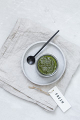 fresh pesto in bowl on marble texture background with copy space