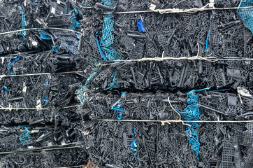 Pressed black plastic crates boxes packed for recycling.