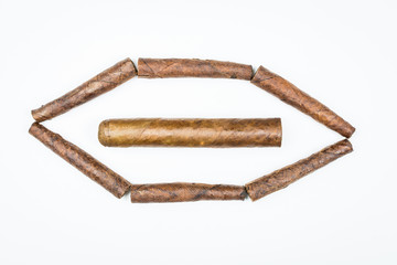 Big and small cigars twisted from sheets of tobacco on white background.