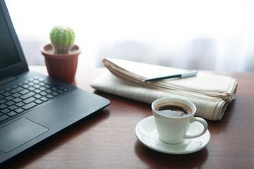 Newspaper with computer on table. Coffee break.