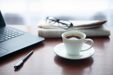 Newspaper with computer on table. Coffee break.