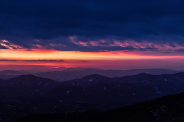 Beautifully colored sky at dusk, with mountains layers