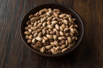 Pistachio Nuts with Shell in Wooden Bowl.