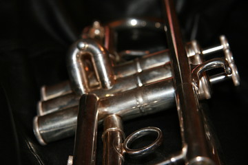 The trumpet valves on the brown background