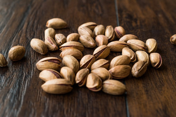 Pistachio Nuts with Shell on Dark Wooden Surface.