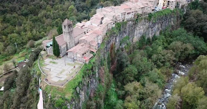 CASTELLLFOLLLIT DE LA ROCA, SPAIN - NOVEMBER 04, 2018:  Aerial view of Castellfollit de la Roca, medieval Catalan hamlet on cliff on autumn day