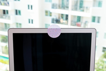 Close up blocks the covered webcam with a white sticker tape