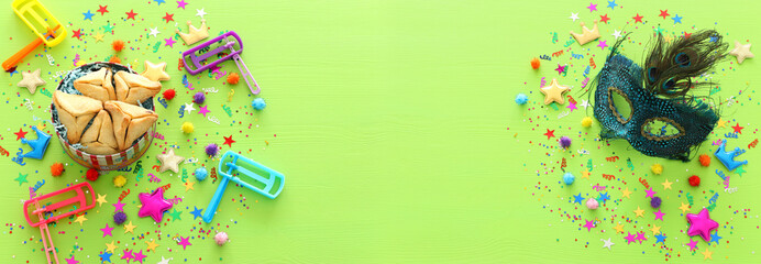 Purim celebration concept (jewish carnival holiday) over wooden green background. top view, flat lay. banner