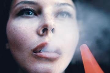 The girl smokes a hookah. Smoke closeup