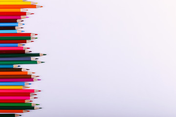 Colored pencils, school supplies for drawing, pattern, copy space.