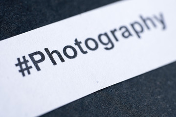 Popular hashtag "photography" printed on white paper on blue background.