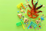 Purim celebration concept (jewish carnival holiday) over wooden green background. top view, flat lay