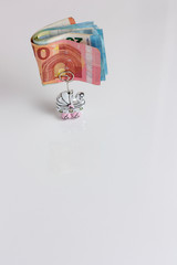 Banknotes folded into a stroller shaped wedding favor on a white background
