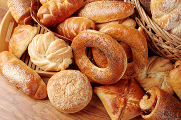 Bakery products on a wooden table. Rolls, donuts, loaves, rolls, cookies.