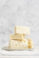 Sliced feta cheese on light background. High key. With copy space