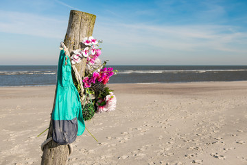 Pfosten mit Kunstblumen- Geheimnis am Strand von Norderney