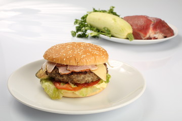 cheeseburger, chicken cutlet, bacon, tomatoes and slices of cheese, dressed with sauce and green salad for a restaurant menu on a white isolated background