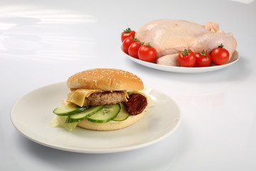 cheeseburger, chicken cutlet, bacon, tomatoes and slices of cheese, dressed with sauce and green salad for a restaurant menu on a white isolated background