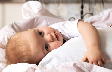 Preparing for bed, cute tired child lying on the bed hugging a pillow