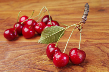 Ripe sweet cherries in a wooden bowl on a wooden table