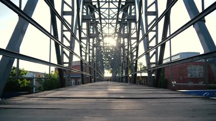 Local metallic bridge with a wooden pavement in the Carpathians in slo-mo
