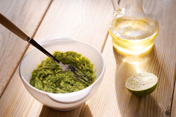 Bowl of guacamole on the wooden table
