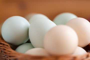 Plain multicoloured free range eggs on wooden plate