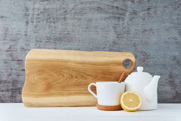 Ceramic teapot, white cup and lemon on a wooden background
