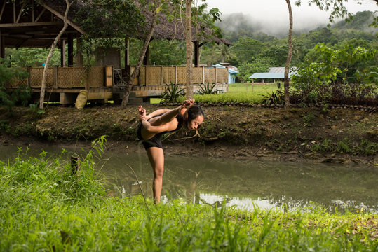 Filipino girl yoga posing in tropical jungle rice fields