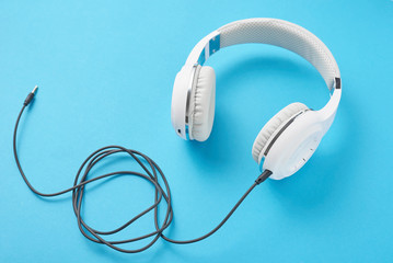 White headphones on a pastel blue background