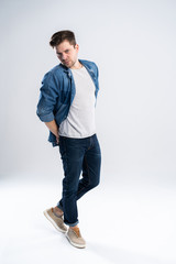 Naklejka premium Full length portrait of a casual man standing over white background.
