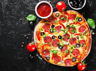 Pepperoni Pizza with Mozzarella cheese, salami, Tomatoes, olive, pepper, Spices and Fresh Basil. Italian pizza on dark background