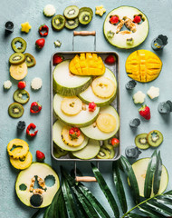 Various colorful fresh fruits and berries in tray , top view. Summer food . Vertical
