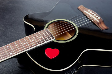 Fototapeta na wymiar   Black acoustic guitar and plectrum in the form of a red heart.