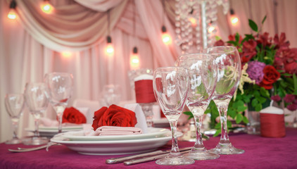 festive table decoration with red flowers and glasses