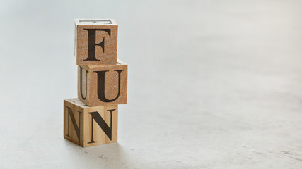 Pile with three wooden cubes - letters FUN on them, space for more text / images on right side.