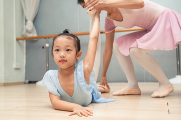 Chinese teacher showstopper student how to make ballet movement during the class at the ballet school