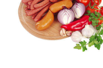 Sausages, sausages, onions, garlic, peppers, tomatoes on the kitchen board.