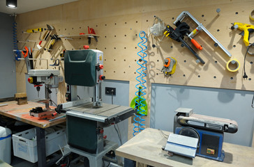 At the workshop: sawing machine, sanding machine and tools on a stand