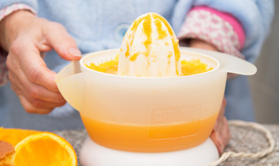 Woman making orange juice in the kitchen