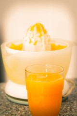 glass of orange juice and juicer
