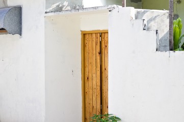 Wooden door of a white maldivian house (Ari Atoll, Maldives)