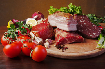Meat products and vegetables. Ham and sausage, lemon, tomatoes, peppers, lettuce and parsley