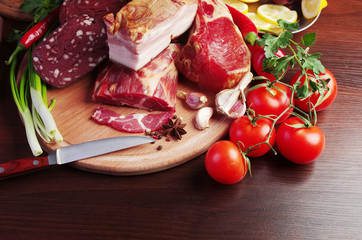 Meat products and vegetables. Ham and sausage, lemon, tomatoes, peppers, lettuce and parsley