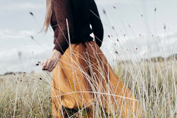 Midsection of woman walking in field