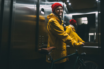 Portrait of a young woman in the elevator along with a bicycle © yossarian6